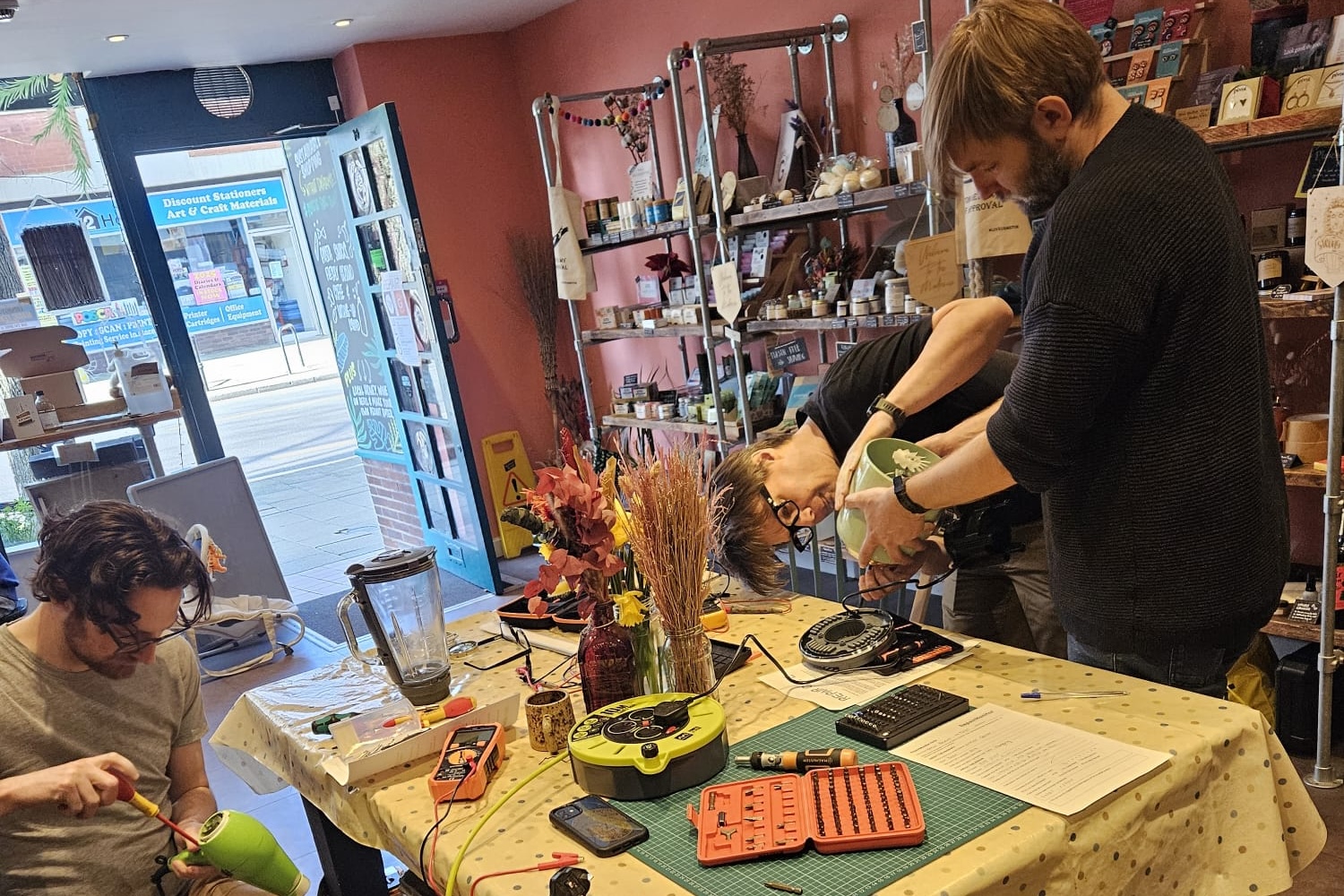 A team of volunteers taking apart a kettle and a hairdryer